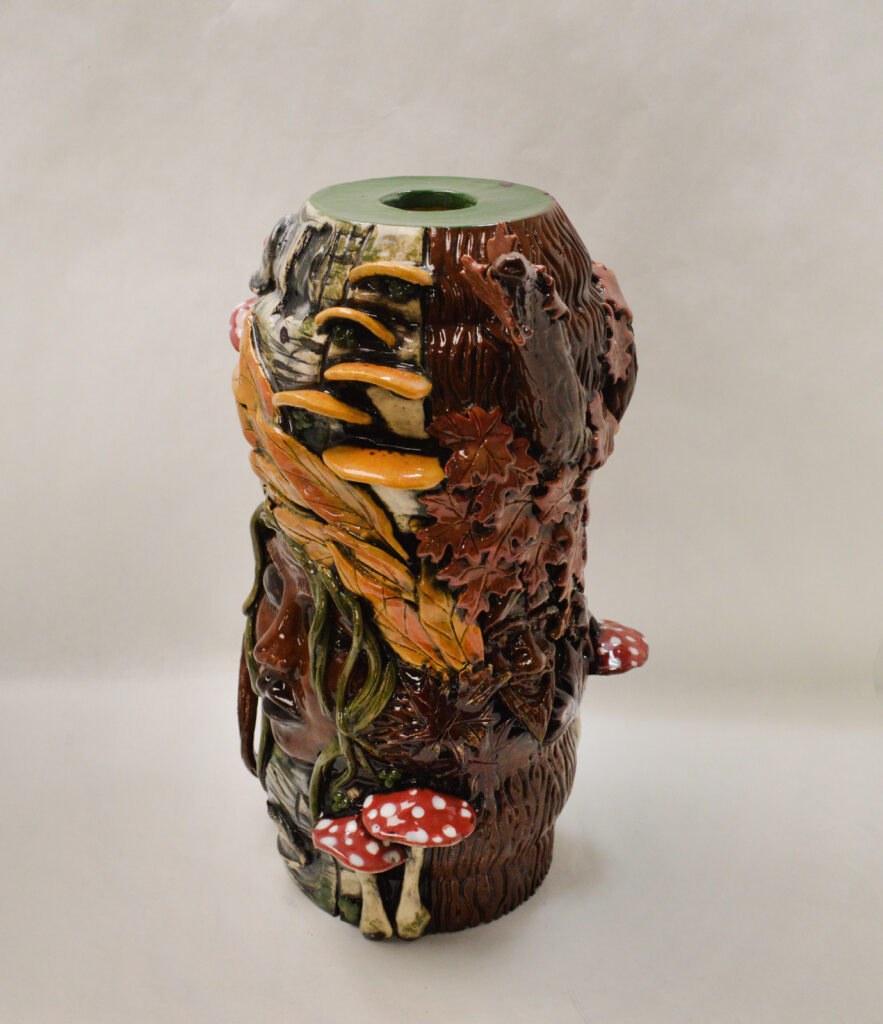 Ceramic vessel featuring textures and glazes that evoke natural elements including leaves, tree bark, and mushrooms