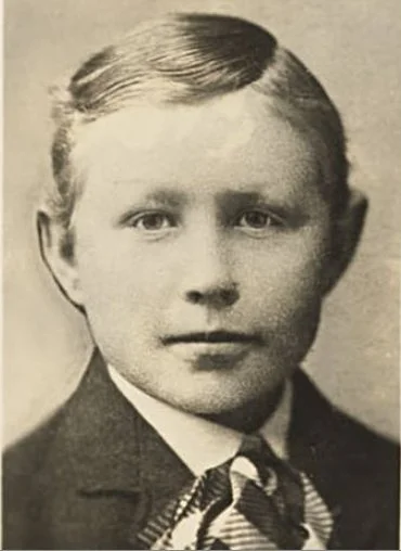 Portrait of young Grant Wood wearing a suit with a slight smile