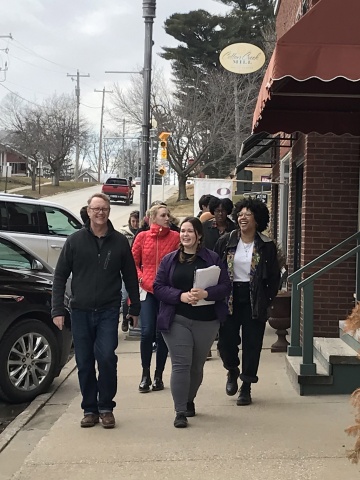 a group of people walk down a street next to buildings