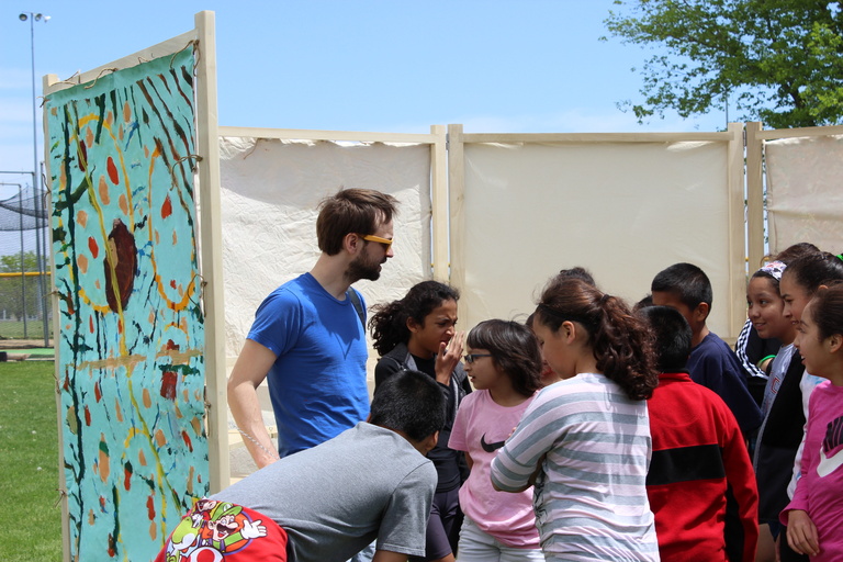 Terry Conrad and students inside a canvas and wood structure