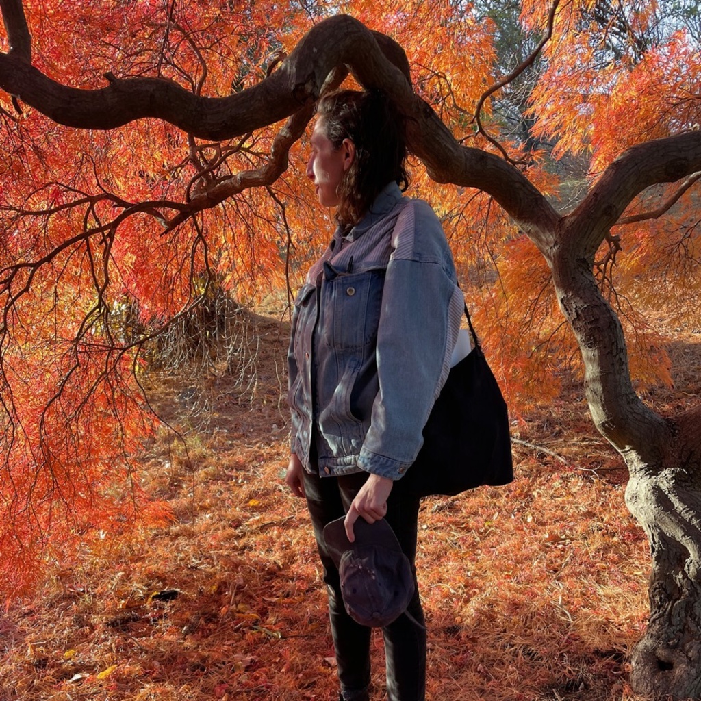 Ada Friedman stands in front of an autumn tree