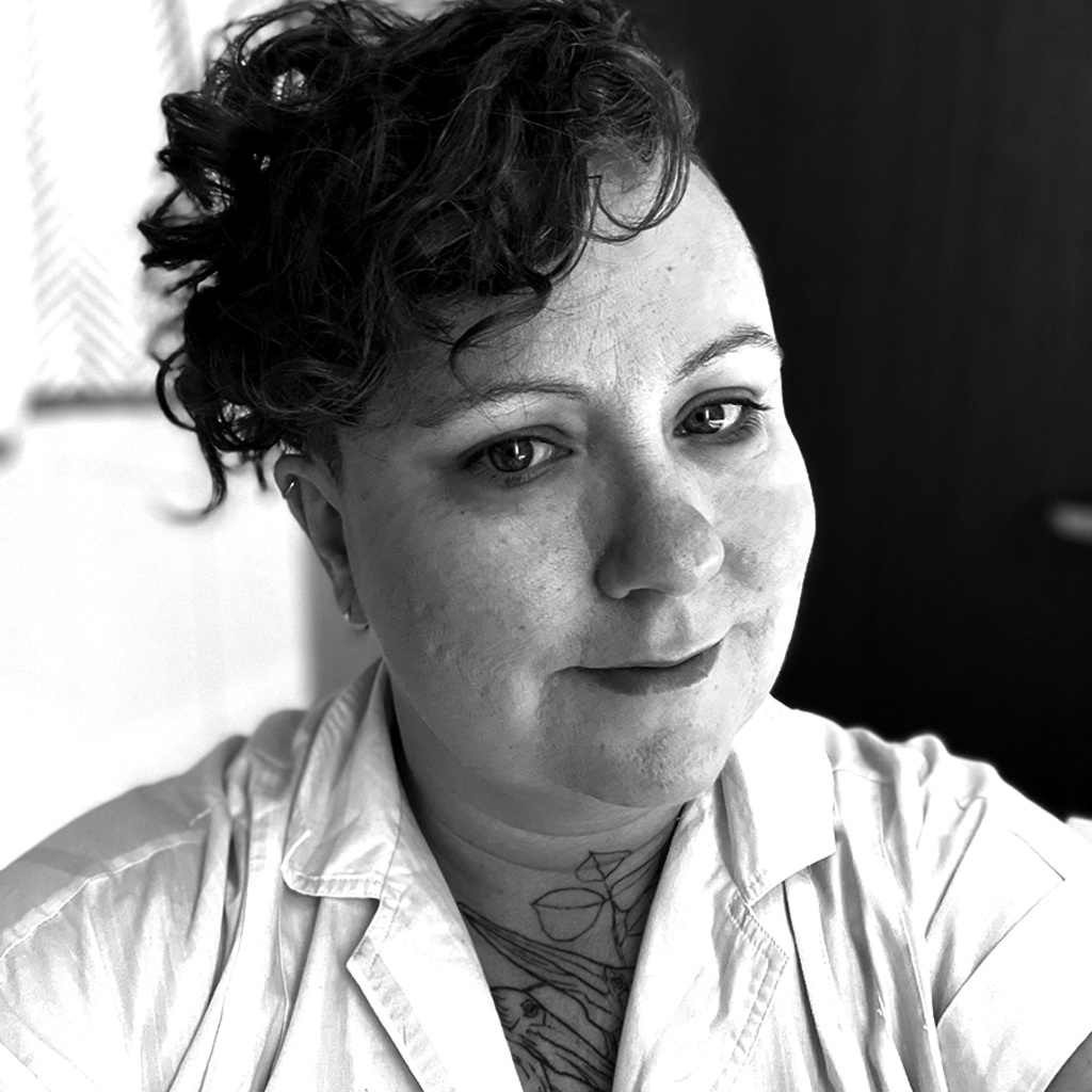 white person with short curly hair and a white shirt