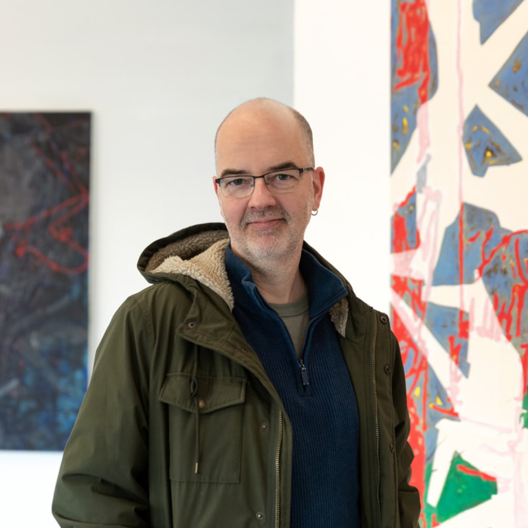 Hartmut Austen stands before a painting