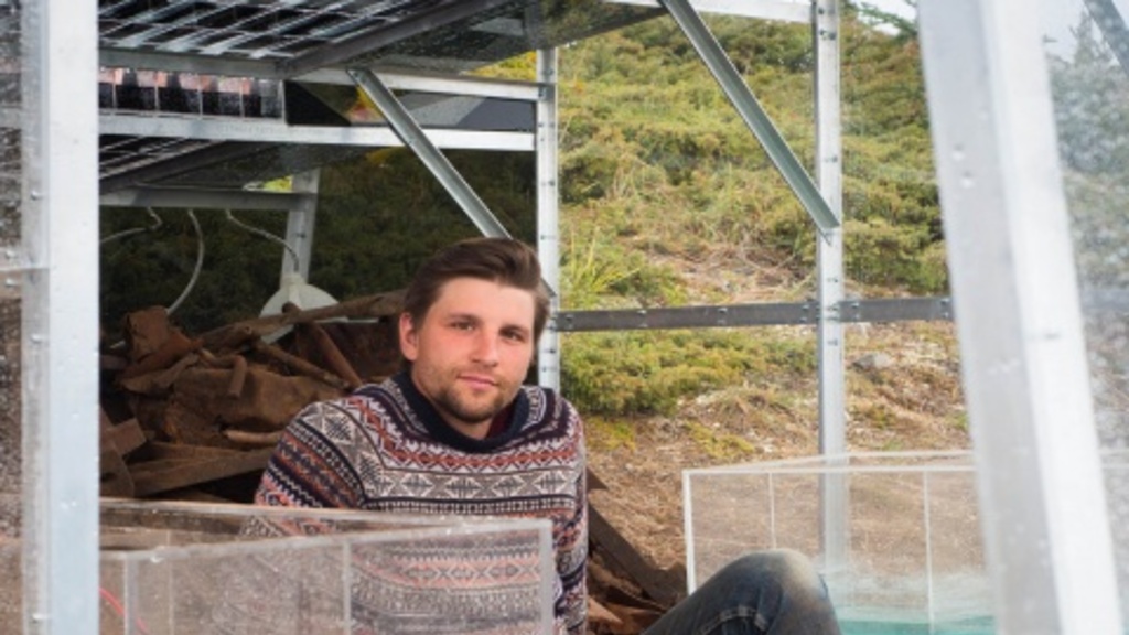 Colin Lyons sits between two water tanks