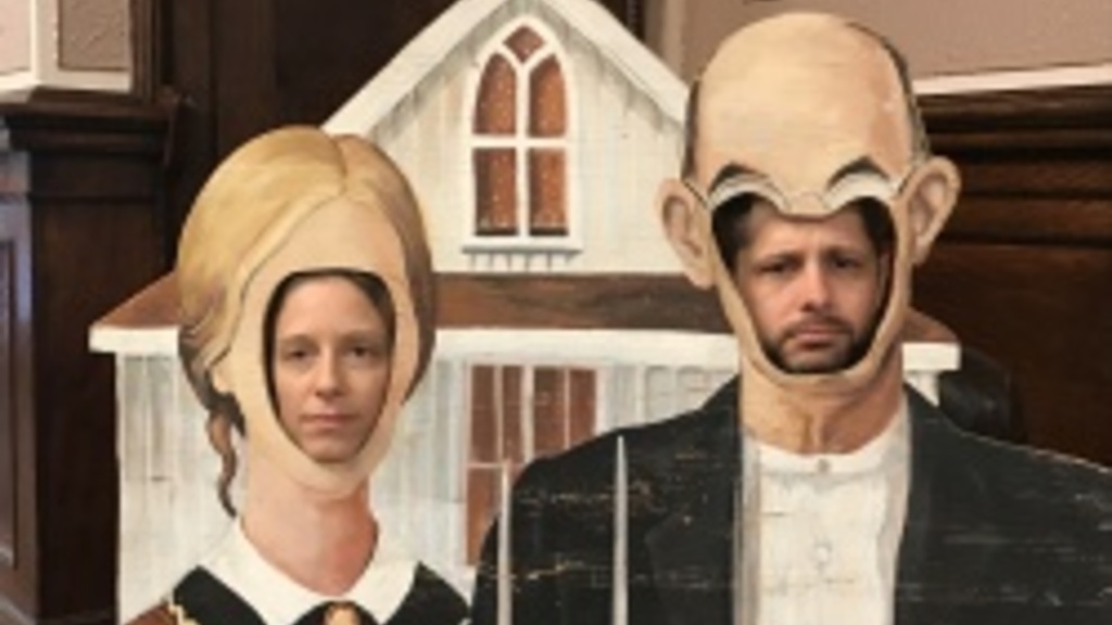 two people putting their heads in the American Gothic painting