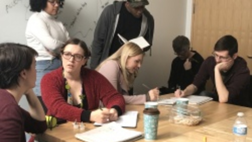 6 students collaborate around a table